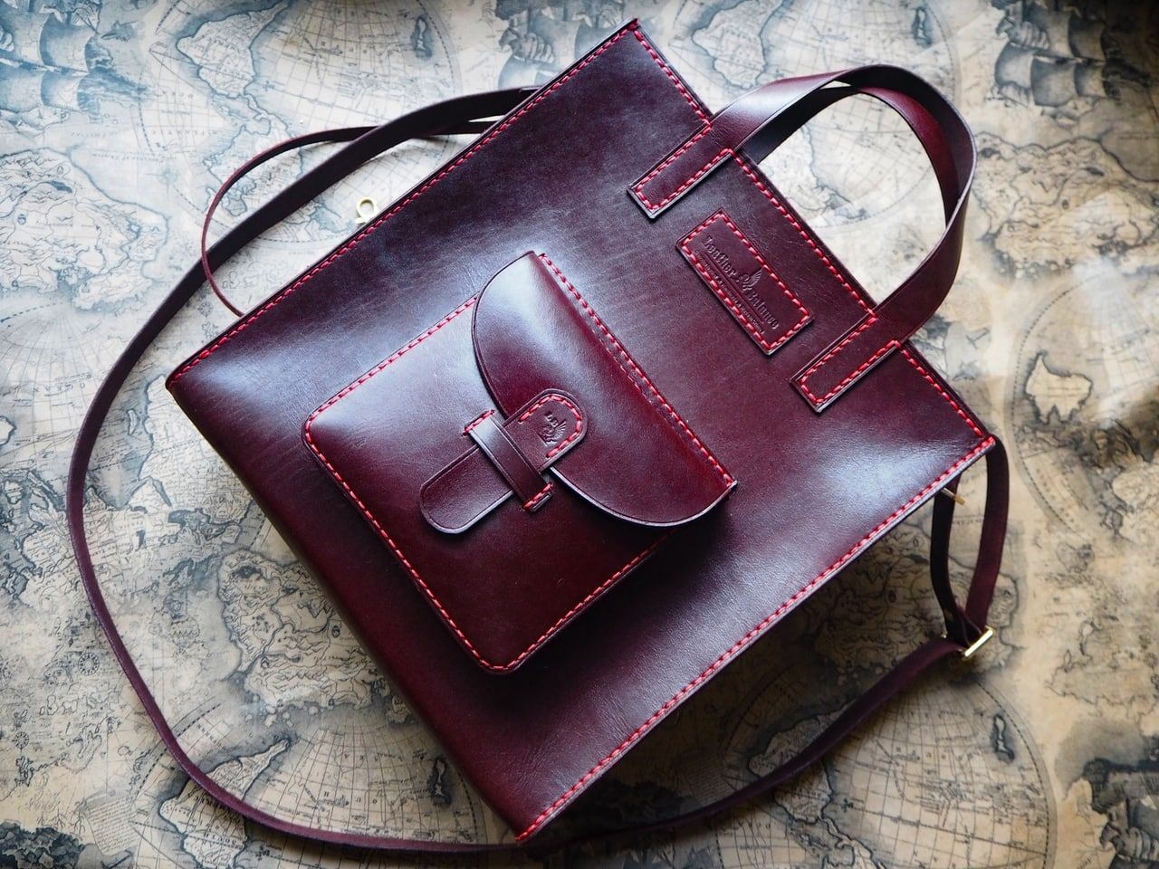 Burgundy leather handbag on a textured surface